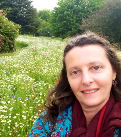 Foto da paisagista Kátia Crespo no Queen's Mary Gardens, em frente a um campo de flores